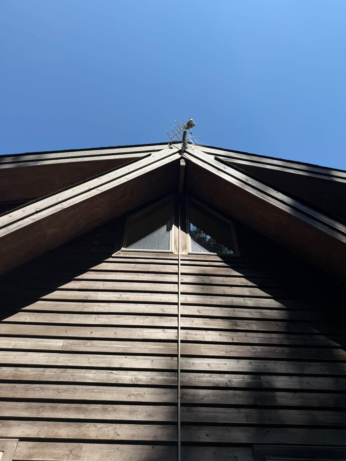 Low-voltage cable neatly routed in exterior raceway down the gable peak of a wood cabin