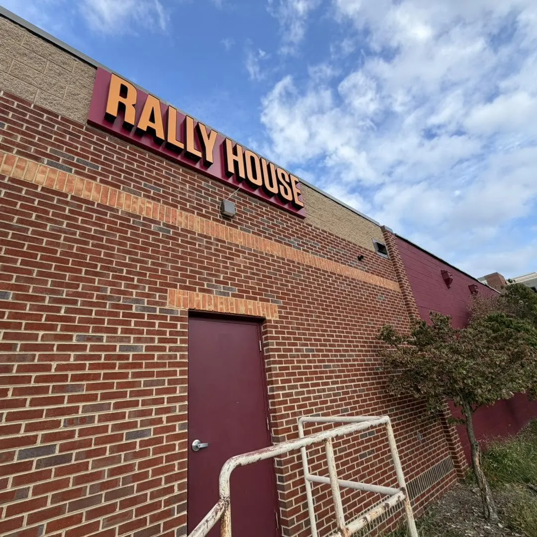 Commercial security camera installation on the brick exterior of a Rally House retail store