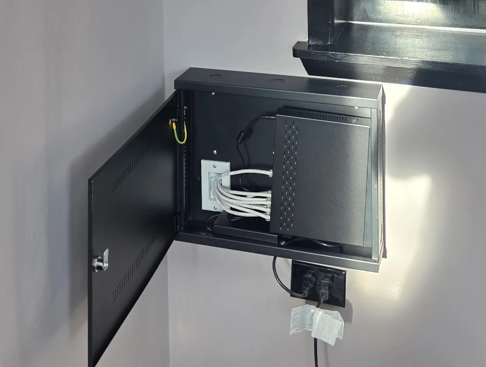 NVR security system installation at Redline Tire and Lube with Cat6 cables terminated inside a wall-mounted enclosure