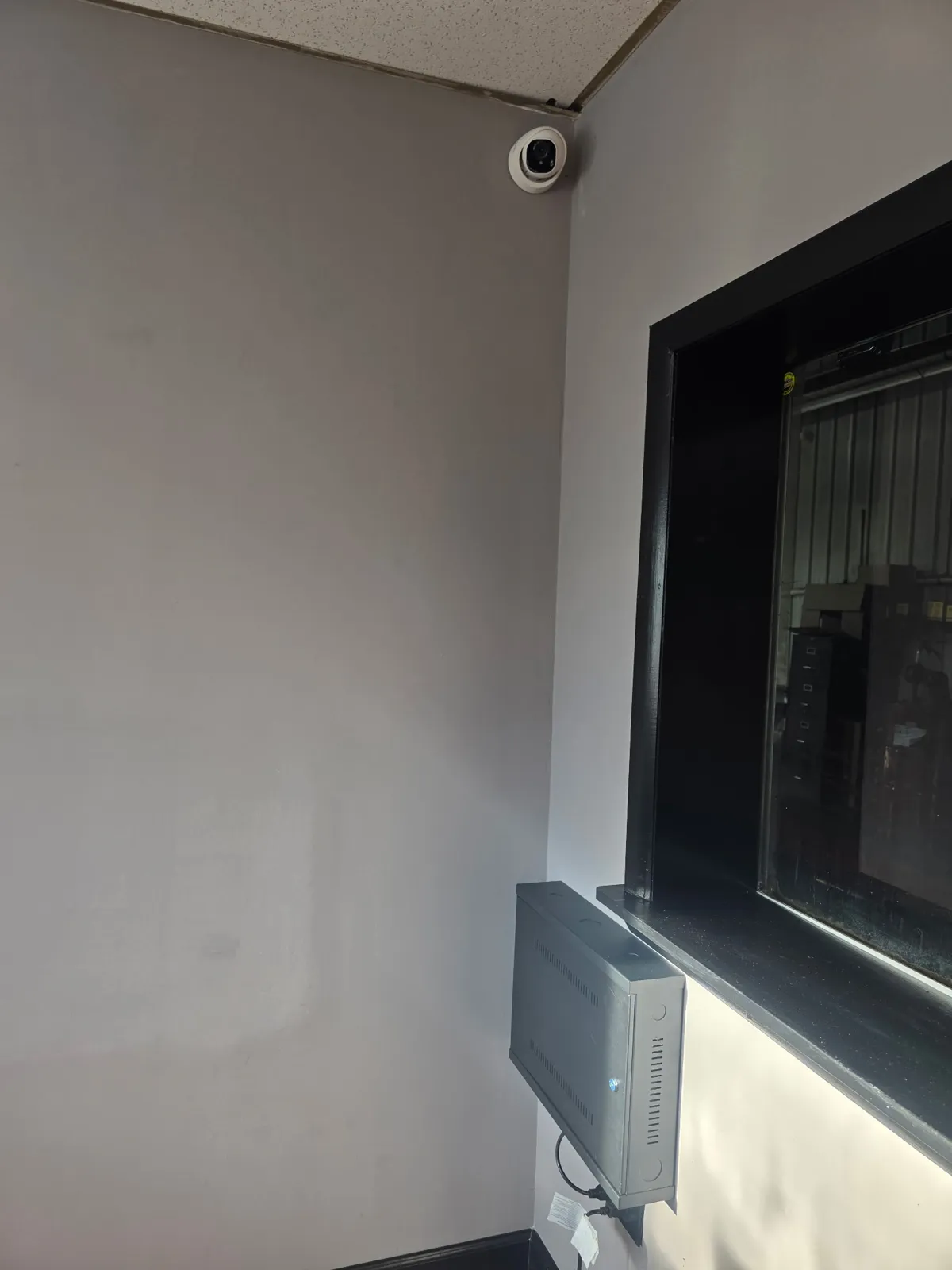 Dome security camera and closed NVR cabinet in the Redline Tire and Lube office
