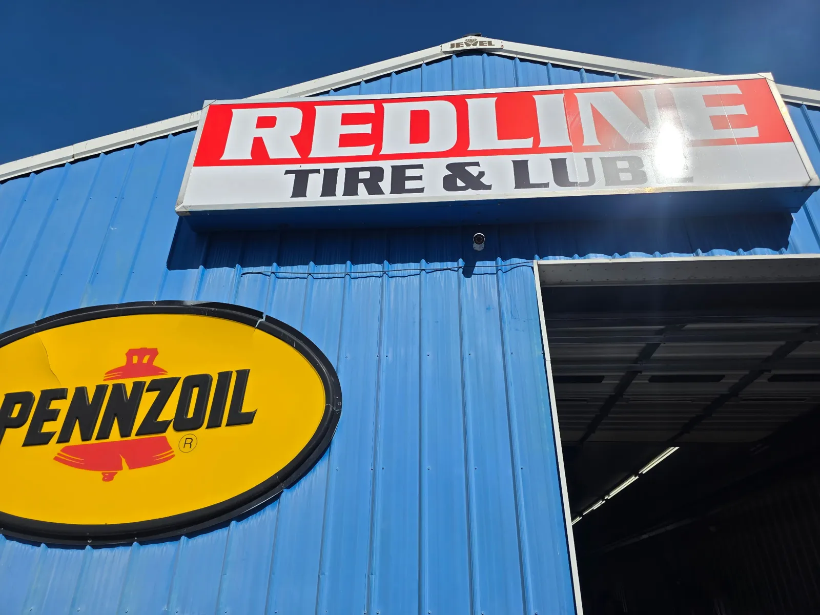 Commercial security camera installed beneath the Redline Tire and Lube sign in Christiansburg VA