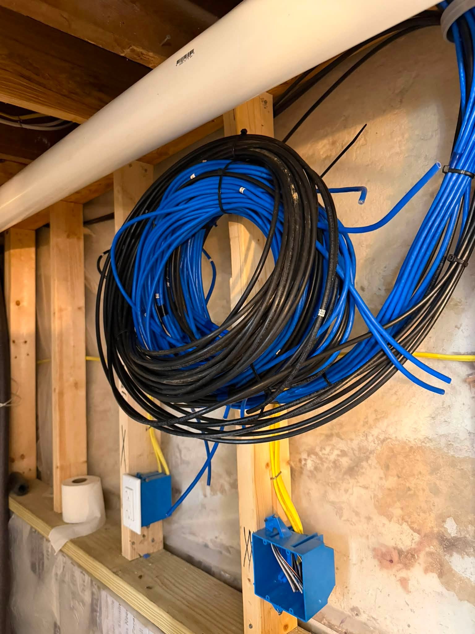Coiled Cat6 and coax cables at junction boxes ready for termination during a residential rough-in