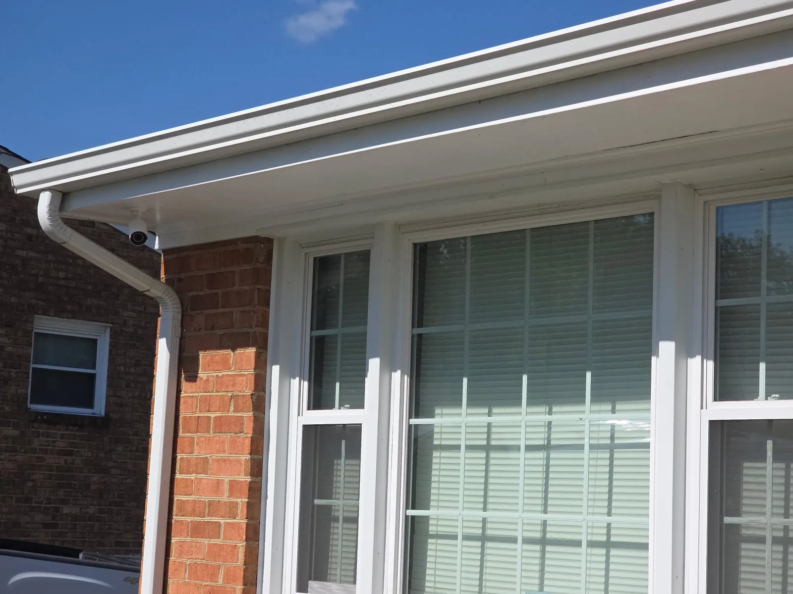 Reolink security camera mounted under the eave beside a downspout on a Salem, VA home