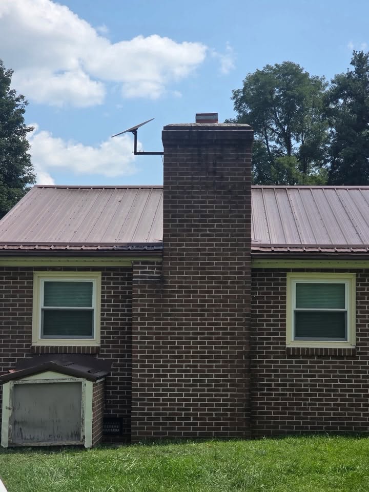 Starlink dish mounted to a brick chimney on a metal-roof home in Southwest Virginia
