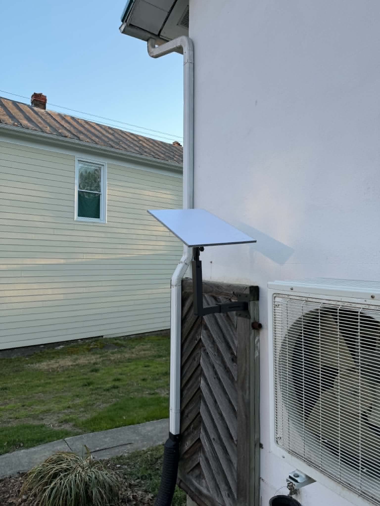 Starlink dish on pole mount beside house